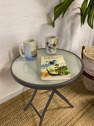 Folding Glass & Metal Table With To Nice Coffee Mugs And A Vintage Heros And Heroin Book