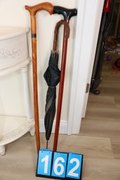 LOT 162 - UMBRELLA AND TWO VINTAGE CANES