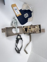 182 - GAME CAMERA IN LOCKBOX, HAT WITH TAGS, ANCHOR WITH TAG AND NICE HEADLAMP