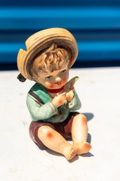 Ceramic Figurine Of A Boy Sitting Down