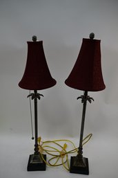 A Pair Of Wooden Based Metal Table Lamps With Palm Tree Form Elements And Burgundy Shades