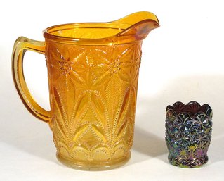 TWO VINTAGE PIECES OF CARNIVAL GLASS, INCLUDING A POINSETTIA PITCHER AND DAISY AND BUTTON TOOTHPICK
