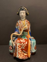 PORCELAIN FIGURE OF A BIJIN Seated On A Bench Reading A Calligraphic Scroll