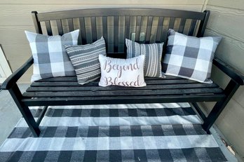 Black Faux Wood Outdoor Bench With Cushions And Black And White Checkered Rug