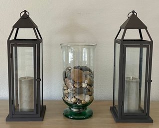 Pair Of Brown Metal And Glass Lanterns With Battery Candles And Art Glass Vase With River Rock