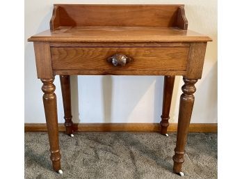 Antique Solid Walnut Single Scallop And Dowel Drawer Table With Raised Back On Porcelain Casters