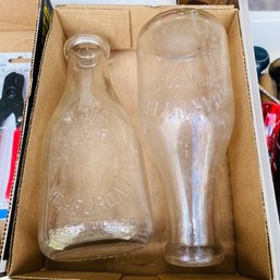 Two Large Glass Milk Bottles (Loc: Left Table)