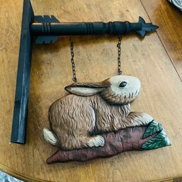 Post With Large Hanging Wooden Rabbit On Carrot