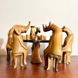 Hand Carved Wooden Safari Animals Sitting Around Table With Drinks