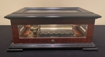 REUGE MUSIC BOX WITH BEVELED CRYSTAL GLASS AND BURL ELM WITH BLACK TRIM