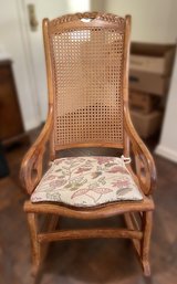 ANTIQUE HAND CARVED ROCKING CHAIR WITH CANE BACK AND SEAT