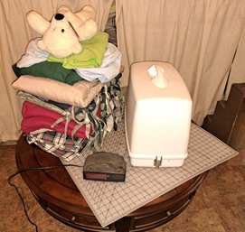 Singer Electric Sewing Machine, Digital Alarm Clock, Cutting Mat, Various Linens.