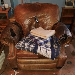 Overstuffed Leather Armchair And Various Blankets.