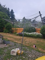 Umbrella Style Clothes Line In Ground And Clothes Pins.