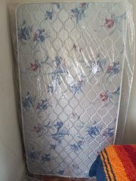 A Thin Twin Mattress In Plastic Wrap, Blankets, And Mattress Toppers