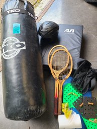 Various Sports Equipment Like LKO Punching Bag, Floor Mat, Tennis Rackets, Helmet And Other Small Sport Items.