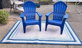 Rm.00. Two Plastic Adirondack Outdoor Chairs And Outdoor Rug.