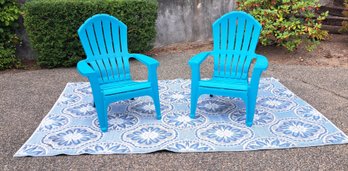 Rm.00. Two Plastic Adirondack Chairs And Outdoor Rug