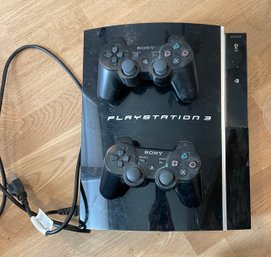 PlayStation 3 With Two Controllers And A Powercord