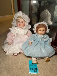 R7 Two Porcelain Baby Dolls Measuring 11 In And 12 In Tall Sitting Down