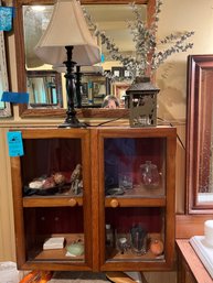 Wall Cabinet With Glass Doors, Lamp, Candle Lantern, Four Tumblers, Bird Figurine, Glass Jar,  Metal Candle