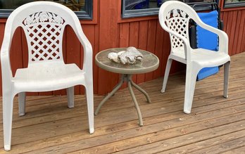 R00 Outdoor Furniture Lot To Include Two Plastic Chairs, A Small Glass Table, And A Folding Hammock Style Chai