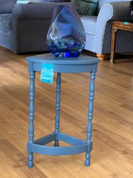 R1 Small Blue Wooden Corner Table With Large Abstract Blue Glass Vase Filled With Glass Pebbles