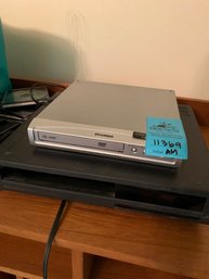 Sylvania DVD Player, Hitachi M123 VCR, Assorted DVDs, Assorted Cords And Electronic Equipment