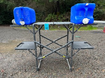 R0 GCI Outdoor Folding Table And Two Water Jugs