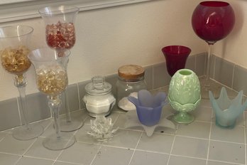 Gardening Stools, Pots, A Decorative Parrot, Bath Salts, Colorful Candleholders And Tall Stemmed Glasses