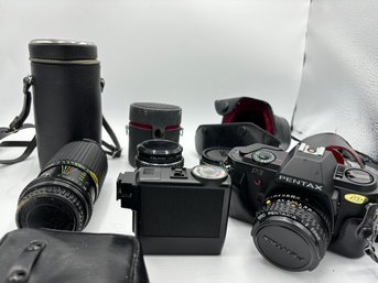 Pentax 35mm Camera With Multiple Lenses, Flash, And Carrying Bag