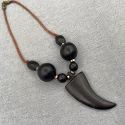 Necklace With Black Tooth Shaped Pendand And Large Beads And Cord