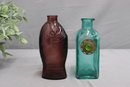 A Pair Of Colored Glass Decorated And Figural Bottles