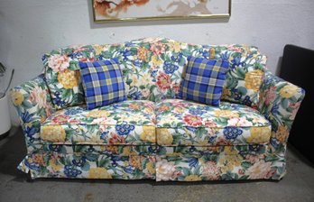Charming Floral Sleeper Sofa With Contrasting Plaid Pillows
