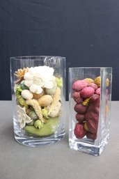 Two Decorative Glass Vases Filled With Artificial Flowers, Bulbs, Berries Etc