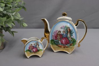 Hand-Painted Watteau Style Gold Embellished Porcelain Teapot And Small Pitcher