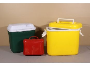 Two Used Colorful Ice Chest Coolers And A Small Red Plastic Case