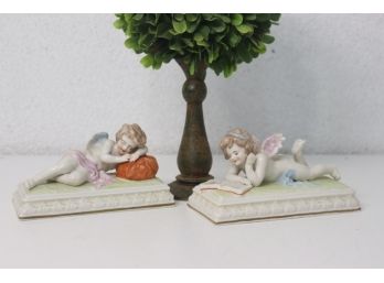 Pair Of German Porcelain Prone Cherubs Reading And Resting