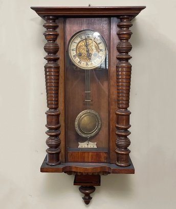 An Antique Wall Clock With Carved Wood Case