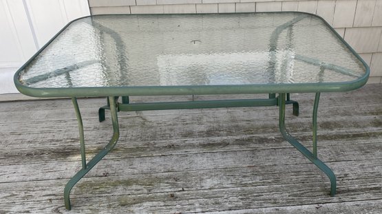 An Outdoor Glass Top Aluminum Frame Patio Dining Table.