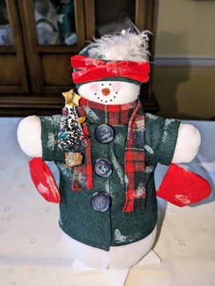 1990s Vintage Snowman Decoration With Green Coat Standing Next To A Christmas Tree