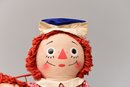 Vintage Raggedy Ann And Andy Dolls Sitting On A Bench