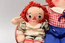 Vintage Raggedy Ann And Andy Dolls Sitting On A Bench