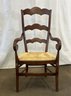 A Vintage French Country Ladderback Arm Chair With Rush Seat