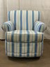 A Vintage Upholstered Arm Chair With A Swivel Base