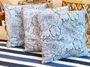 A Trio Of Blue And White Decorative Pillows