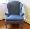 A Blue Wing Back Chair With Carved Legs