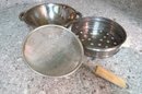 A Grouping Of Pots, Pans And Strainers