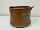 An Antique Copper Pot With Brass Handles