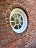 A Pair Of Round Windows Flanking Front Entry